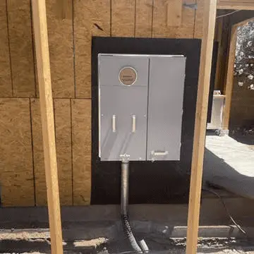 Electrical panel installed on a construction site with wooden framing.